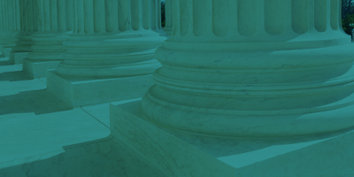 Teal-tinted photograph of the bases of several Doric columns.