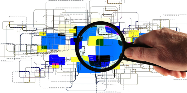 Rendering of a hand holding a magnifying glass over symbolic stacks of electronic files.