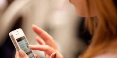 Photograph of a woman using a mobile phone.