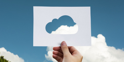 Artist's rendering of man holding a card with a cloud-shaped cutout against a cloudy blue sky.