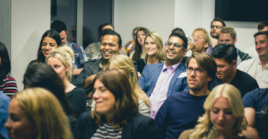 Photograph of a modest audience in a small conference room.